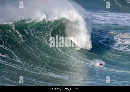 Ein Surfer reitet auf einer stürzenden Welle, Nazare, Portugal Stockfoto