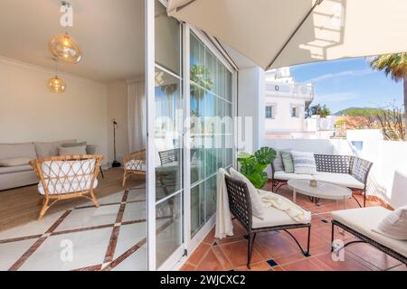 Bild einer mediterranen Gartenterrasse mit offener Tür zum Wohnzimmer Stockfoto