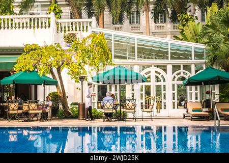 Das Mittagessen wird den Hotelgästen im Gartenrestaurant im Innenhof, Sofitel Legend Metropole, Hanoi Vietnam, serviert Stockfoto