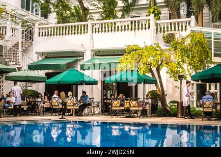 Hotelgäste essen im Gartenrestaurant im Innenhof, Sofitel Legend Metropole, Hanoi Vietnam, zu Mittag Stockfoto