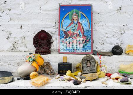 Buddhistische Statuen und Heilige Reliquien werden als Opfergaben auf den Stufen des Karo-La Pass Stupa, oder Chorten, in den Himalaya-Bergen des Autonomen Tibet hinterlassen Stockfoto