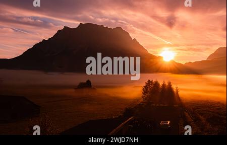 Nebeliger Blick auf den alpinen Sonnenaufgang mit Zugspitze bei Lermoos, Reutte, Tirol, Österreich Lermoos AX 044 Stockfoto