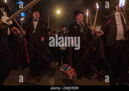 Madrid, Madrid, Spanien. Februar 2024. Mitglieder der Sardinenbruderschaft tragen während der Prozession einen Sarg mit einer künstlichen Sardine. Die Sardinenprozession, die in Madrid stattfindet, ist eine jahrhundertealte spanische Tradition, die durch ein Gemälde des spanischen Künstlers Francisco de Goya, das Begräbnis der Sardinen, berühmt wurde. Es markiert das Ende der Karnevalsfeiern und den Beginn der Fastenzeit 40 Tage vor Ostern. Es besteht aus einer Prozession, die eine Beerdigung parodiert, bei der eine symbolische Figur einer Sardine in ihrem Sarg verbrannt wird. Das fest findet jeden Aschermittwoch und jeden Aschermittwoch statt Stockfoto