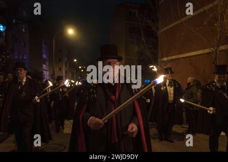 Madrid, Madrid, Spanien. Februar 2024. Mitglieder der Sardinenbruderschaft werden während der Prozession mit Fackeln beleuchtet. Die Sardinenprozession, die in Madrid stattfindet, ist eine jahrhundertealte spanische Tradition, die durch ein Gemälde des spanischen Künstlers Francisco de Goya, das Begräbnis der Sardinen, berühmt wurde. Es markiert das Ende der Karnevalsfeiern und den Beginn der Fastenzeit 40 Tage vor Ostern. Es besteht aus einer Prozession, die eine Beerdigung parodiert, bei der eine symbolische Figur einer Sardine in ihrem Sarg verbrannt wird. Das fest findet jeden Aschermittwoch statt und symbolisiert Stockfoto