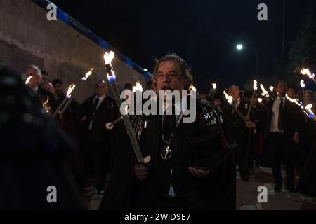 Madrid, Madrid, Spanien. Februar 2024. Mitglieder der Sardinenbruderschaft werden während der Prozession mit Fackeln beleuchtet. Die Sardinenprozession, die in Madrid stattfindet, ist eine jahrhundertealte spanische Tradition, die durch ein Gemälde des spanischen Künstlers Francisco de Goya, das Begräbnis der Sardinen, berühmt wurde. Es markiert das Ende der Karnevalsfeiern und den Beginn der Fastenzeit 40 Tage vor Ostern. Es besteht aus einer Prozession, die eine Beerdigung parodiert, bei der eine symbolische Figur einer Sardine in ihrem Sarg verbrannt wird. Das fest findet jeden Aschermittwoch statt und symbolisiert Stockfoto