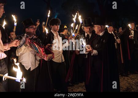 Madrid, Madrid, Spanien. Februar 2024. Mitglieder der Sardinenbruderschaft werden mit Fackeln gesehen, die sich darauf vorbereiten, das Bild der Sardine in einem Lagerfeuer zu verbrennen. Die Sardinenprozession, die in Madrid stattfindet, ist eine jahrhundertealte spanische Tradition, die durch ein Gemälde des spanischen Künstlers Francisco de Goya, das Begräbnis der Sardinen, berühmt wurde. Es markiert das Ende der Karnevalsfeiern und den Beginn der Fastenzeit 40 Tage vor Ostern. Es besteht aus einer Prozession, die eine Beerdigung parodiert, bei der eine symbolische Figur einer Sardine in ihrem Sarg verbrannt wird. Das fest findet e statt Stockfoto