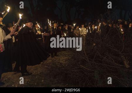 Madrid, Madrid, Spanien. Februar 2024. Ein Mitglied der Bruderschaft der Sardine wirft das Bild der Sardine ins Lagerfeuer. Die Sardinenprozession, die in Madrid stattfindet, ist eine jahrhundertealte spanische Tradition, die durch ein Gemälde des spanischen Künstlers Francisco de Goya, das Begräbnis der Sardinen, berühmt wurde. Es markiert das Ende der Karnevalsfeiern und den Beginn der Fastenzeit 40 Tage vor Ostern. Es besteht aus einer Prozession, die eine Beerdigung parodiert, bei der eine symbolische Figur einer Sardine in ihrem Sarg verbrannt wird. Das fest findet jeden Aschermittwoch statt und symbolisiert das b Stockfoto