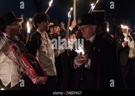 Madrid, Madrid, Spanien. Februar 2024. Mitglieder der Sardinenbruderschaft werden mit Fackeln gesehen, die das Bild der Sardine in einem Lagerfeuer verbrennen. Die Sardinenprozession, die in Madrid stattfindet, ist eine jahrhundertealte spanische Tradition, die durch ein Gemälde des spanischen Künstlers Francisco de Goya, das Begräbnis der Sardinen, berühmt wurde. Es markiert das Ende der Karnevalsfeiern und den Beginn der Fastenzeit 40 Tage vor Ostern. Es besteht aus einer Prozession, die eine Beerdigung parodiert, bei der eine symbolische Figur einer Sardine in ihrem Sarg verbrannt wird. Das fest findet e statt Stockfoto