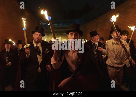 Madrid, Madrid, Spanien. Februar 2024. Mitglieder der Sardinenbruderschaft werden während der Prozession mit Fackeln beleuchtet und getanzt. Die Sardinenprozession, die in Madrid stattfindet, ist eine jahrhundertealte spanische Tradition, die durch ein Gemälde des spanischen Künstlers Francisco de Goya, das Begräbnis der Sardinen, berühmt wurde. Es markiert das Ende der Karnevalsfeiern und den Beginn der Fastenzeit 40 Tage vor Ostern. Es besteht aus einer Prozession, die eine Beerdigung parodiert, bei der eine symbolische Figur einer Sardine in ihrem Sarg verbrannt wird. Das fest findet jeden Aschermittwoch und jeden Aschermittwoch statt Stockfoto