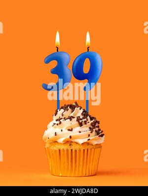 Blaue Kerze Nummer 39 - Geburtstagskuchen auf orangem Hintergrund Stockfoto