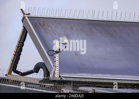 Solarpaneele mit Stacheln zum Abstoßen von Tauben auf dem Dach eines Hauses mit einem Wärmesystem zur Erwärmung von Wasser Stockfoto