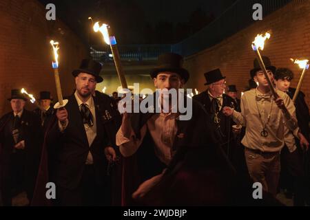 Madrid, Spanien. Februar 2024. Mitglieder der Sardinenbruderschaft werden während der Prozession mit Fackeln beleuchtet und getanzt. Das fest findet jeden Aschermittwoch statt und symbolisiert das Begräbnis der Vergangenheit und die Wiedergeburt der Gesellschaft. Es markiert das Ende der Karnevalsfeiern und den Beginn der Fastenzeit 40 Tage vor Ostern. Es besteht aus einer Prozession, die eine Beerdigung parodiert, bei der eine symbolische Figur einer Sardine in ihrem Sarg verbrannt wird. (Kreditbild: © Guillermo Gutierrez Carrascal/ZUMA Press Wire) NUR REDAKTIONELLE VERWENDUNG! Nicht für kommerzielle ZWECKE! Stockfoto