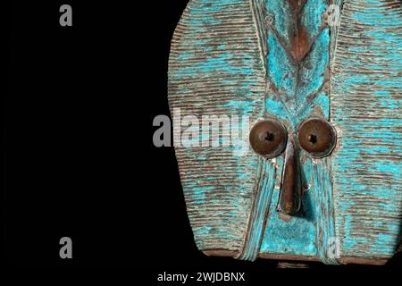 Nahaufnahme einer hölzernen Kota-Reliquienfigur aus Gabun, isoliert auf schwarzem Hintergrund. Afrikanische Kunst mit meisterhafter Handwerkskunst und spir Stockfoto