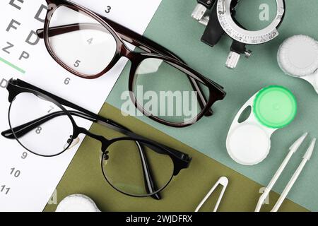 Flache Lay-Komposition mit Vision-Testkarte und Brille auf farbigem Hintergrund Stockfoto