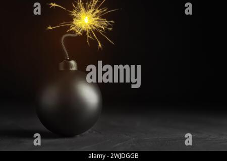 Altmodische schwarze Bombe mit beleuchteter Sicherung auf grauem Tisch, Platz für Text Stockfoto