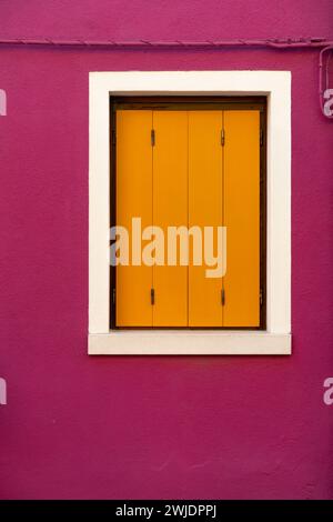 Vorderansicht eines venezianischen Gebäudes Fassadenfenster mit Holzläden und bemalten Wänden. Stockfoto