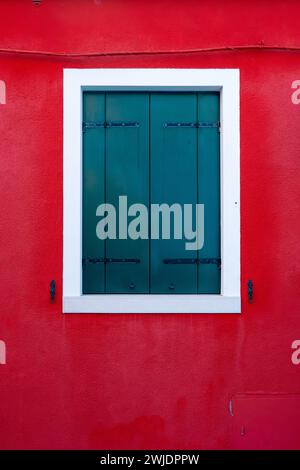 Vorderansicht eines venezianischen Gebäudes Fassadenfenster mit Holzläden und bemalten Wänden. Stockfoto