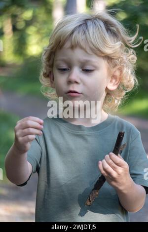 Ein kleiner Junge erkundet die Natur auf einem Waldweg Stockfoto