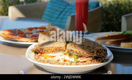 Auswahl an Speisen auf dem Tisch Sandwiches, Pizza und Teller Stockfoto