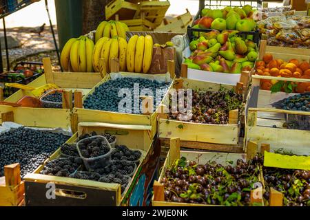 Obst und Gemüse in Holzkisten auf einem freien Markt in Trebinje, Bosnien. Frisches Obst wie Bananen, Birnen, Kirschen auf dem Display. Stockfoto