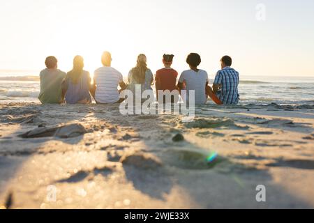 Verschiedene Gruppen von Freunden sitzen am Strand, mit Kopierraum Stockfoto