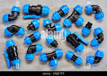 Druckspannarmaturen aus Polypropylen für Rohrleitungssysteme aus HDPE-Rohren auf grauem Schieferblech. Stockfoto