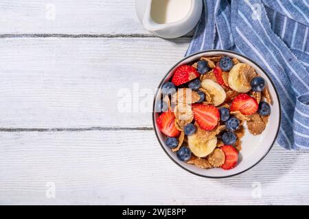 Gesunde Vitamindiät Sommerfrühstück. Cornflakes mit mehreren Körnern, Joghurt oder Milch und Erdbeeren, Blaubeeren, auf dem Küchentisch Kopierraum Stockfoto