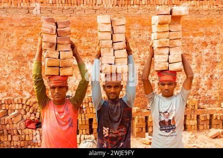 Dhaka, Dhaka, Bangladesch. Februar 2024. Arbeiter tragen in einem Ofen in Dhaka, Bangladesch, Steine mit einem Gewicht von mehr als 20 kg auf dem Kopf. Die Arbeiter '''', die weniger als Â£1 pro Schicht ''''' erhalten, bewegen bis zu 2.500 Steine pro Tag unter heißen Bedingungen. Rund 4 00.000 einkommensschwache Migranten kommen jedes Jahr aus verschiedenen Teilen des Landes nach Dhaka, um in brickfields zu arbeiten. Lange Arbeitszeiten unter sengender Sonne auf den Ziegelfeldern, massive Staubansammlungen, Sturzgefahr von LKW und Ziegelhaufen und das Tragen übermäßiger Lasten stellen eine ernste Gesundheitsgefährdung für die W dar Stockfoto