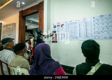 Ein Wahlbeamter, der ein Batman-Kostüm trägt, arbeitet während des indonesischen Präsidenten am 14. Februar 2024 in einem Wahllokal in Bogor, Indonesien Stockfoto