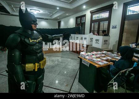 Ein Wahlbeamter, der ein Batman-Kostüm trägt, arbeitet während des indonesischen Präsidenten am 14. Februar 2024 in einem Wahllokal in Bogor, Indonesien Stockfoto