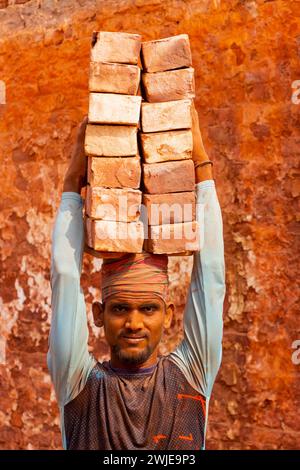 Dhaka, Dhaka, Bangladesch. Februar 2024. Arbeiter tragen in einem Ofen in Dhaka, Bangladesch, Steine mit einem Gewicht von mehr als 20 kg auf dem Kopf. Die Arbeiter '''', die weniger als Â£1 pro Schicht ''''' erhalten, bewegen bis zu 2.500 Steine pro Tag unter heißen Bedingungen. Rund 4 00.000 einkommensschwache Migranten kommen jedes Jahr aus verschiedenen Teilen des Landes nach Dhaka, um in brickfields zu arbeiten. Lange Arbeitszeiten unter sengender Sonne auf den Ziegelfeldern, massive Staubansammlungen, Sturzgefahr von LKW und Ziegelhaufen und das Tragen übermäßiger Lasten stellen eine ernste Gesundheitsgefährdung für die W dar Stockfoto