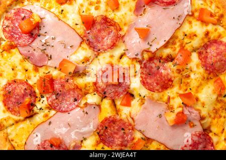 Hintergrund mit köstlicher klassischer italienischer Pizza-Peperoni mit Würstchen und Käse-Mozzarella. Frische, klassische italienische Paprika-Pizza. Stockfoto