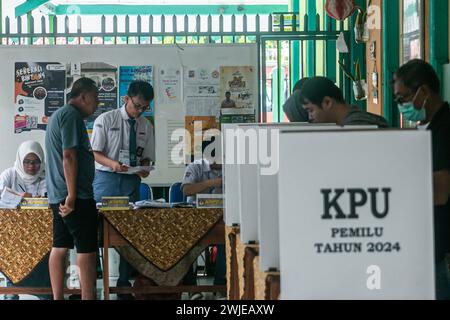 Beamte der Personalwahl trugen Schuluniformen in einem Wahllokal bei den Parlamentswahlen in Bogor, Indonesien, am 14. Februar 2024 Stockfoto