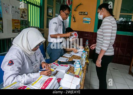 Beamte der Personalwahl trugen Schuluniformen in einem Wahllokal bei den Parlamentswahlen in Bogor, Indonesien, am 14. Februar 2024 Stockfoto