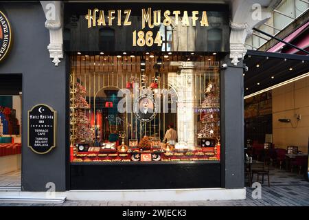 Istanbul, Türkei - 10. Dezember 2023: Eintritt zum Ismail Hakkizade Hafiz Mustafa 1864 Baklava-Laden und -Café in der Yeniceriler-Straße. Die Leute essen Tur Stockfoto