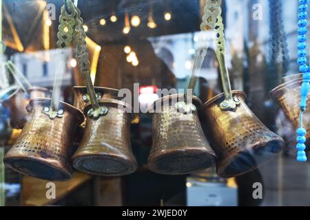 Сezves im Schaufenster, um türkischen Kaffee zuzubereiten. Traditioneller Cezve oder Kaffeekanne für türkische Kaffeekochen auf heißem Sand im traditionellen orientalischen Stil Stockfoto
