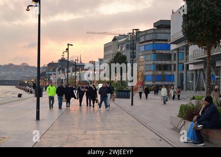 Istanbul, Türkei - 11. Dezember 2023: Die Menschen spazieren abends auf dem Stadtdamm. Galataport Promenade Stockfoto