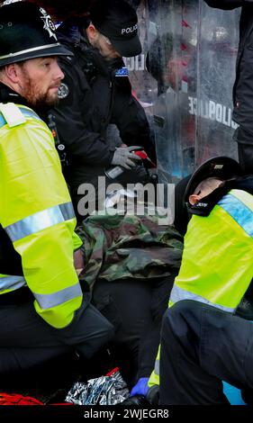 Spezialpolizisten aus dem Schnittteam entfernen während des Protestes einen Demonstranten aus ihrer Sperre. Unterstützer der Palästinensischen Aktion blockieren den einzigen Fahrzeugzugang zur israelischen Verteidigungsfirma, dem Geschäft von Elbit Systems in Aztec West, Bristol. Sie argumentieren, dass die von Elbit in Großbritannien hergestellten Waffen von der israelischen Verteidigungsstreitkräfte gegen Palästinenser in Gaza und anderswo eingesetzt werden. Bei den israelischen Bombenanschlägen im Gazastreifen sind seit Oktober 2023 mehr als 30.000 Palästinenser ums Leben gekommen. Palestine Action ist entschlossen, Elbit und seine Partnerunternehmen durch direkte Maßnahmen unerbittlich ins Visier zu nehmen Stockfoto