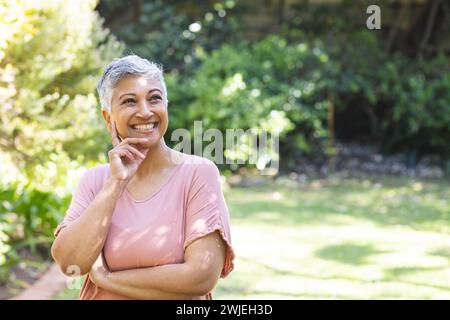 Eine reife Frau mit birassischer Seniorin genießt einen sonnigen Tag im Garten, mit unverändertem Kopierraum Stockfoto