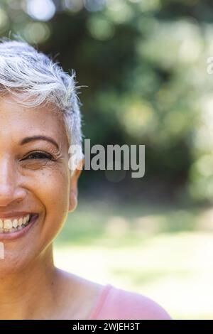 Eine reife Frau lächelt draußen, mit unverändertem Kopierraum Stockfoto