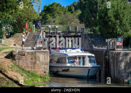 Das Boot überquert den Ecluse de Pechlaurier Look. Canal du Midi im Dorf Argens-Minervois Aude Südfrankreich Südfrankreich Wasserstraßen Urlaub Stockfoto