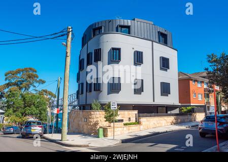 Mit der Sydney Harbour Bridge im Hintergrund hebt sich dieser modern gestaltete Apartmentblock von den nahe gelegenen älteren Gebäuden in McMahons Point ab Stockfoto