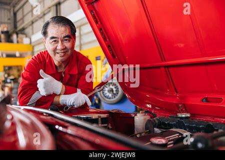 Glückliche Senior professionelle asiatische männliche Mechaniker Garage Arbeiter glückliche Arbeit ersetzen Wartung Auto Service in der Autowerkstatt Stockfoto