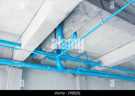 Installation einer wasserblauen pvc-Kunststoffleitung am Erdgeschossdach im Unterbau Stockfoto