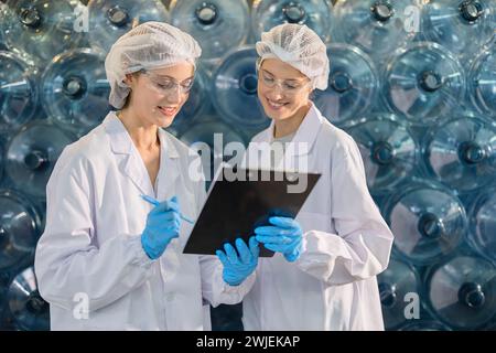 Teamleiter der Produktqualitätskontrolle arbeitet in der Trinkwasserfabrik zusammen, um die Sauberkeit der Produkte zu überprüfen Stockfoto