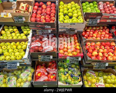 Italien - 17. Januar 2024: Äpfel verschiedener Typen und Farben in Kisten, die auf dem Stand zum Verkauf im italienischen Gemüseladen ausgestellt werden Stockfoto