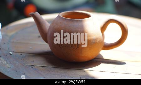 Eine Nahaufnahme einer Teekanne aus Ton auf einem Holztisch Stockfoto