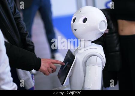 Turin, Italien - 14. Februar 2024: Pepper, ein Roboterassistent mit Informationsbildschirm, begrüßt Besucher an einem Stand der Künstlichen Intelligenz fo Stockfoto