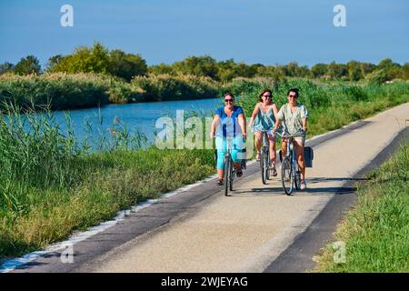 Vauvert (Südostfrankreich): Radtour entlang des Canal de Rhone a Sete (Rhone-Sete-Kanal). Drei Frauen, die auf der „ViaRhona“ in Gallici Fahrrad fahren Stockfoto