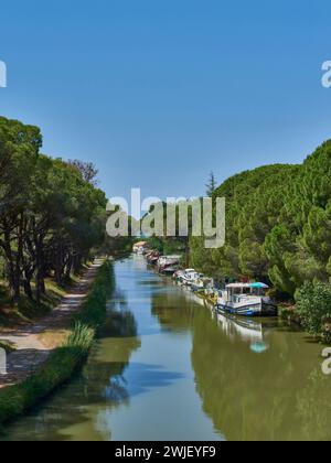 Salleles-d'Aude (Südfrankreich): Binnenschiffe auf dem Canal du Midi zwischen Salleles-d'Aude und Le Somail. Kanalufer mit Schleppweg, Bäumen und Grünweg. T Stockfoto